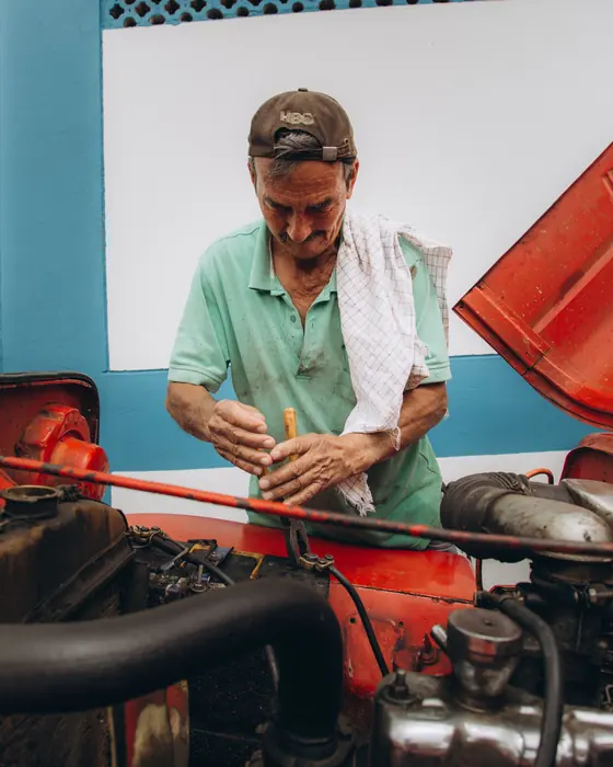 Senior mechanic performing maintenance on a car engine