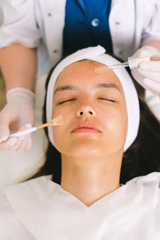 Esthetician applying serum during a facial