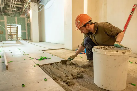 Installer laying tile during a renovation