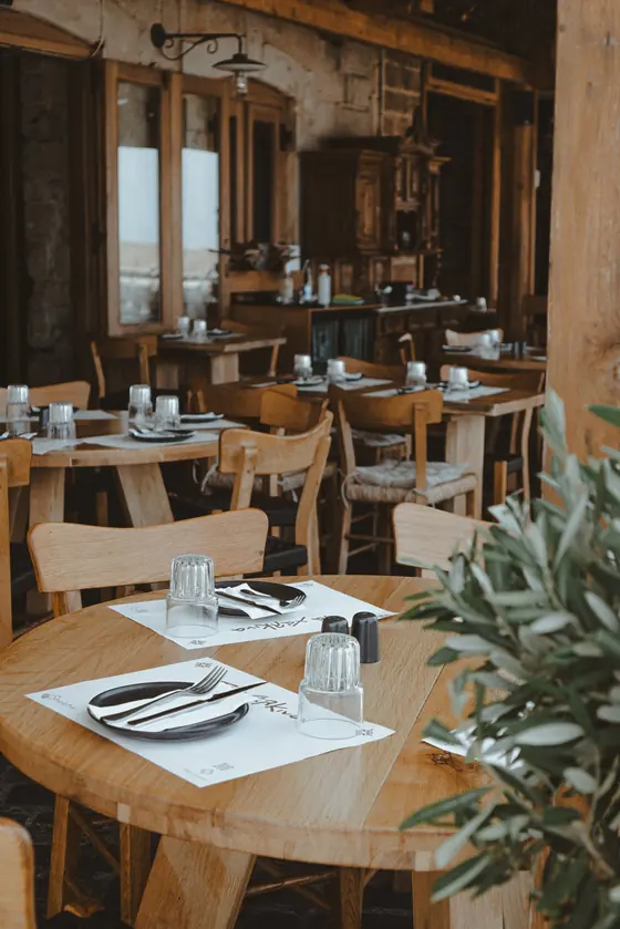 Rustic dining room with wooden tables set for dinner