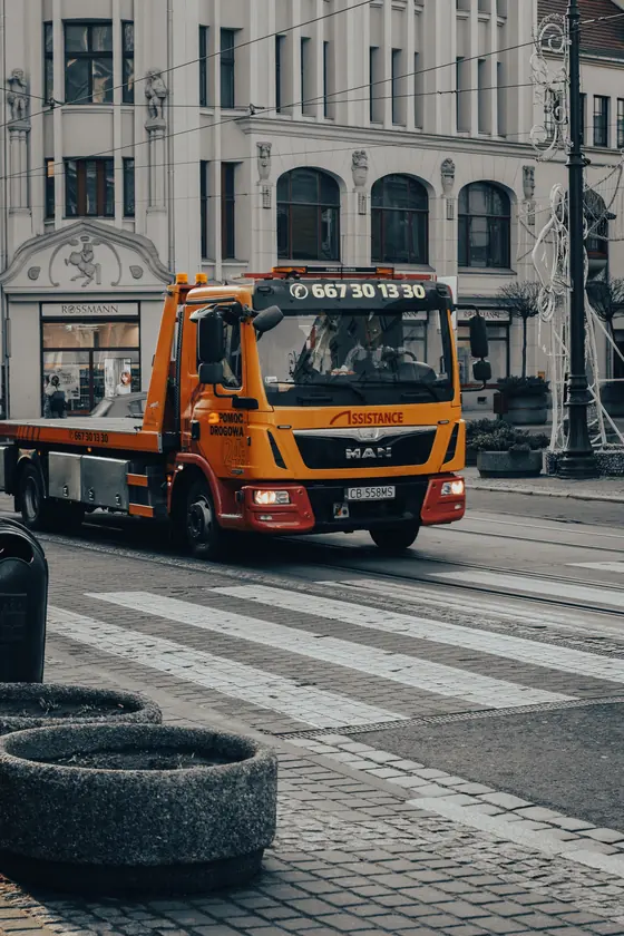 Yellow flatbed tow truck on a city street